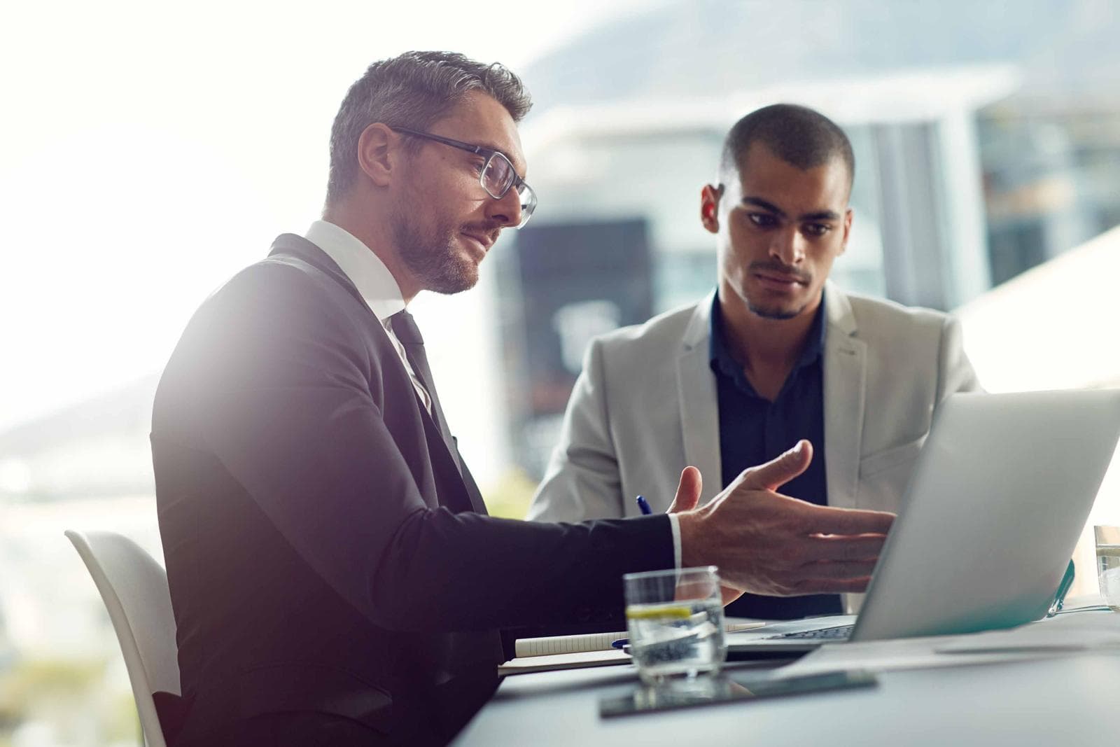 Two people talking in front of a laptop